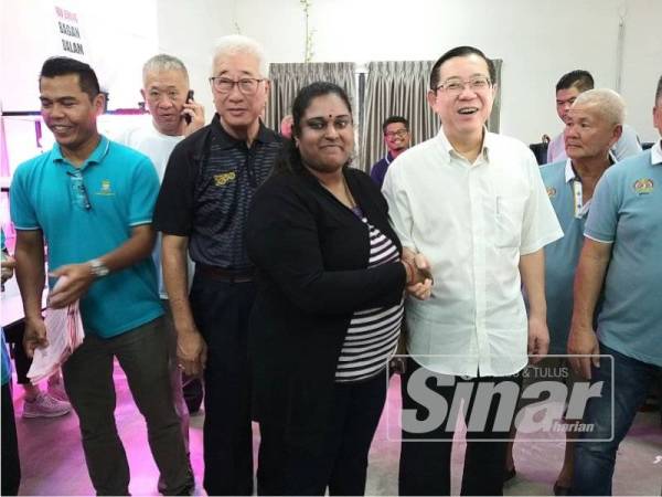 Guan Eng bersalaman dengan penerima wang sumbangan tadi.