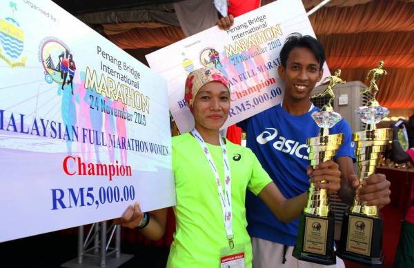 Nik Fakaruddin Ismail bersama isterinya, Nur Amelia Musa menjadi juara Malaysia bagi kategori larian penuh lelaki dan wanita pada Pertandingan Maraton Antarabangsa Jambatan Pulau Pinang hari ini. -Foto Bernama