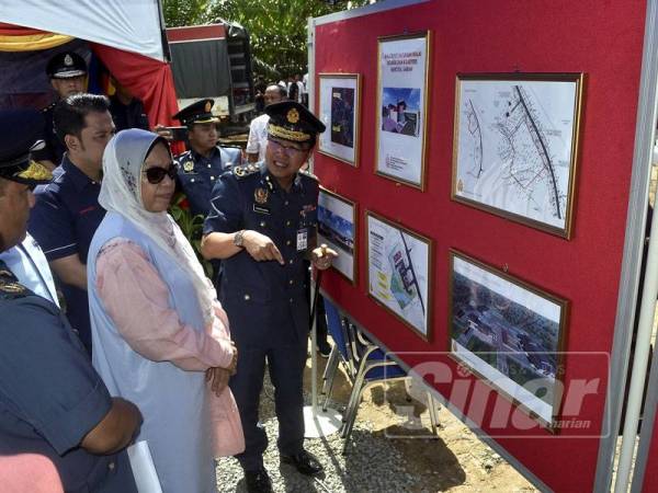 Zuraida (tengah) mendengar penerangan mengenai bangunan baru Balai Bomba dan Penyelamat Merotai termasuk kuarters bernilai RM8.6 juta sebelum menyempurnakan majlis pecah tanah projek berkenaan hari ini. -Foto Bernama