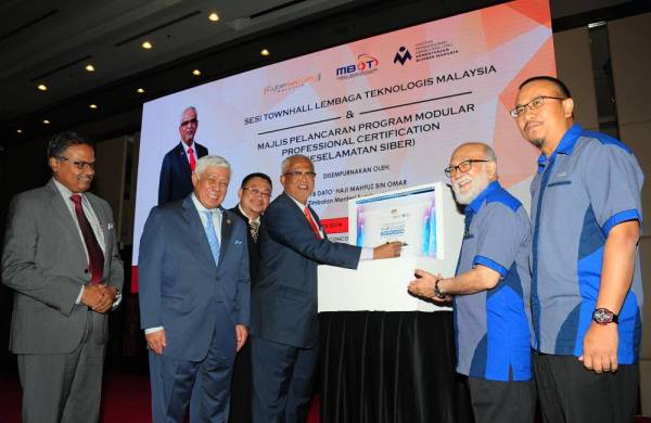 Mahfuz menandatangani plak simbolik melancarkan Program Modular Professional Certification (Keselamatan Siber) hari ini. -Foto Bernama