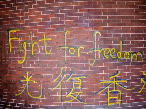 Grafiti bertulis 'fight for freedom' dilihat pada dinding kampus Universiti Politeknik Hong Kong (PolyU) di mana puluhan penunjuk perasaan prodemokrasi masih bertahan. - Foto AFP