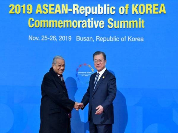 Perdana Menteri, Tun Dr Mahathir Mohamad bersalaman bersama Presiden Korea Selatan Moon Jae-in ketika hadir pada Sidang Kemuncak Peringatan ASEAN-Republik Korea hari ini. - Foto Bernama