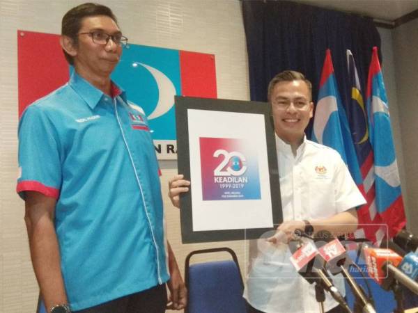 Fahmi menunjukkan logo rasmi Kongres Nasional PKR di Melaka pada 5 hingga 8 Disember nanti.