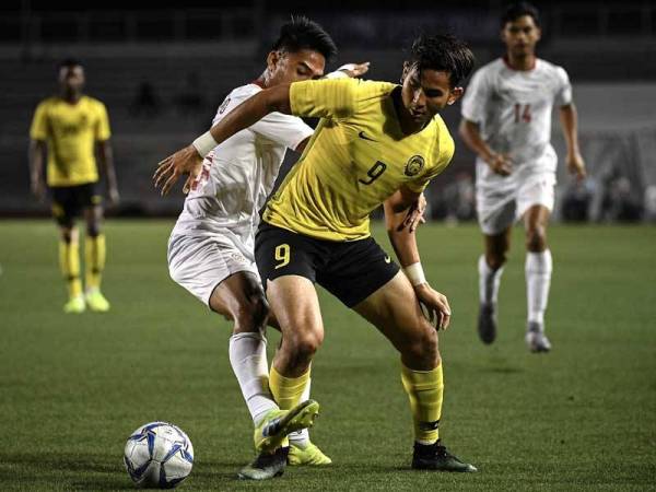 Pemain negara Muhammad Hadi Fayyadh Abdul Razak (depan, kanan) diasak pemain Filipina pada aksi kumpulan A di Stadium Rizal Memorial hari ini. -Foto Bernama