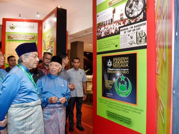 Dr Mahathir (dua dari kiri) yang juga Yang Dipertua Perkim mendengar penerangan daripada Setiausaha Agung Kehormat Perkim, Tan Sri Mohd Yusof Noor ketika melawat ruang pameran sempena Mesyuarat Agung Tahunan Perkim Peringkat Kebangsaan Kali ke-58 hari ini. - Foto Bernama