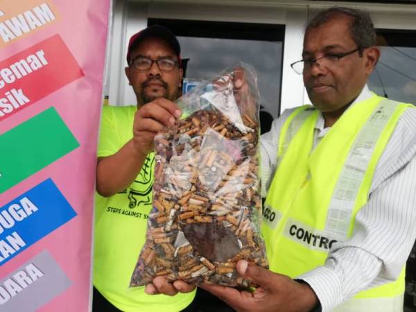 Muhammad Sha'ani (kanan) dan Azkandar menunjukkan ribuan puntung rokok yang berjaya dikutip sempena kempen tersebut di beberapa lokasi hari ini.