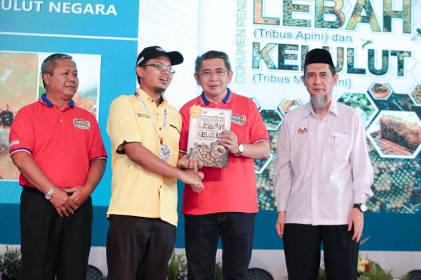 Salahuddin (dua dari kanan) menyampaikan buku Pelan Pembangunan Industri Kelulut Negara 2020-2030 kepada usahawan lebah kelulut selepas melancarkan pelan tersebut dan Pensijilan myGAP Pemeliharaan Lebah dan Kelulut di Angsana Johor Bahru Mall semalam. -Foto Sinar Harian ZAHID IZZANI