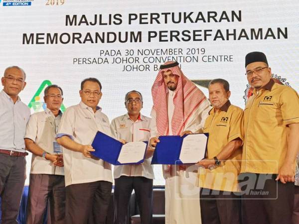 Muhammad Razman dan Abdul Fattah menyaksikan pertukaran MoU antara ASEAN Cooperative Organization (ACO) serta Huda Capital dari Arab Saudi bagi pelaburan umrah dan ziarah.