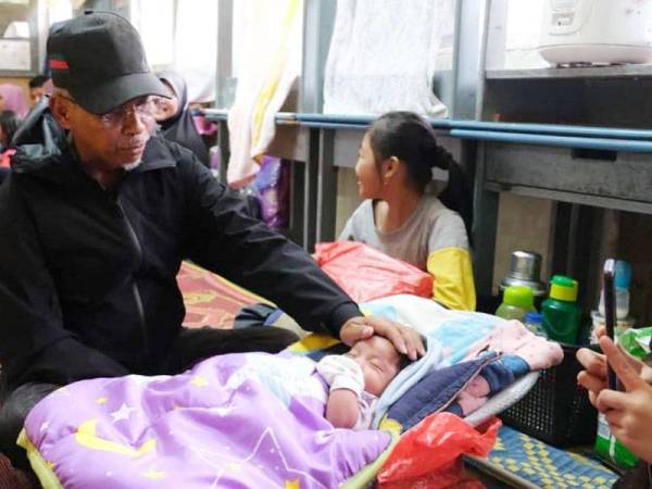 Hanafiah melihat seorang bayi yang ditempatkan di PPS di daerah Besut ketika melakukan tinjauan ke pusat pemindahan mangsa banjir petang semalam.