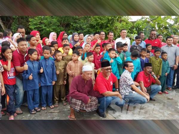 Ahmad Faizal (berdiri, tengah) bersama-sama peserta program Berkhatan Beramai-ramai anjuran Bersatu Chepor Dalam/Kampung Seri Klebang di Dewan Orang Ramai Kampung Sri Klebang, di sini hari ini.