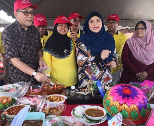 Izham (kiri) merasai sendiri lauk asam pedas dalam pertandingan masakan sempena Program Sukaneka D Bendang di Tali Air Tiga, Ban Satu, Sungai Burong hari ini.