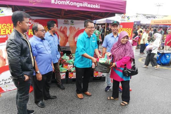 Fakhrul Anuar (dua dari kanan) menyampaikan sumbangan kepada peserta.