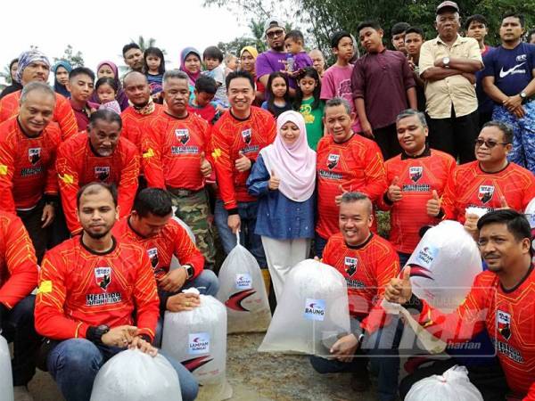 Aminuddin (baris dua, tiga dari kanan) bersama belia Negeri Sembilan sebelum perlepasan anak ikan di pertemuan Sungai Muar dan Sungai Jempol hari ini.