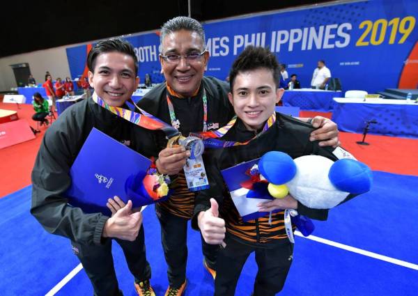 Ketua Kontinjen Malaysia Datuk Megat Zulkarnain Omardin (tengah) bersama atlet wushu lelaki negara, Loh Choon How. -Foto Bernama