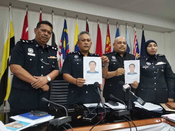 Mohd Said (dua dari kiri) menunjukkan gambar Zarulfekri Amran yang dicari polis bagi membantu siasatan.