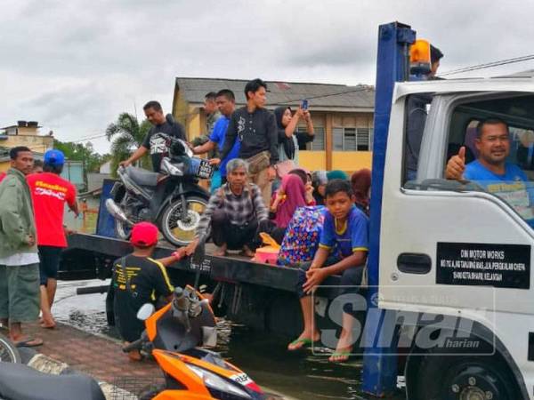 Samarudin (depan) menggunakan lorinya memberikan perkhidmatan kepada orang ramai yang mahu berulang-alik ke pekan Rantau Panjang.