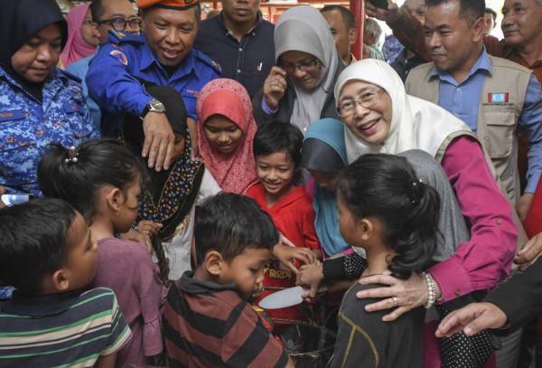 Dr Wan Azizah (dua dari kanan) meraikan ulang tahun kelahirannya bersama kanak-kanak mangsa banjir di PPS Sekolah Kebangsaan Kamil 1 hari ini. -Foto Bernama 