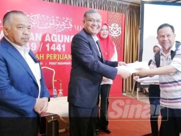 Dr Shamsul Anuar (tengah) menyerahkan tag media PAU 2019 kepada wakil media sewaktu Pelancaran Laman Media Perhimpunan Agung UMNO 2019 di Laman Media, Bilik Mawar, PWTC, Kuala Lumpur hari ini.