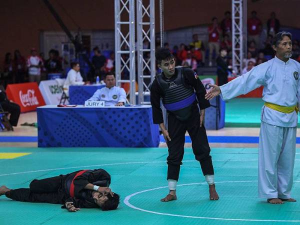 Faizul terbaring selepas terkena tendangan Dumaan pada pusingan kedua Kelas Putra B (50-55kg) acara pencak silat Sukan SEA 2019 hari ini.