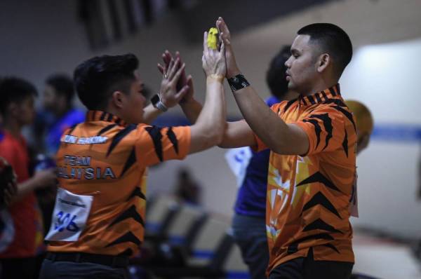 Muhammad Rafiq (kanan) dan Tun Ameerul Luqman beraksi dalam acara tenpin boling men’s double kategori lelaki akhir sempena Sukan SEA Filipina 2019 di Starmall EDSA Manila hari ini.