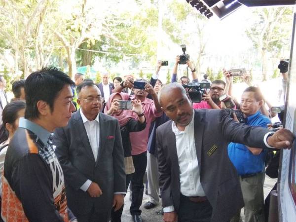 Takashima (dua dari kiri) bersama-sama delegasi diberikan penerangan mengenai Taman Jepun ketika lawatan ringkas ke taman itu hari ini.