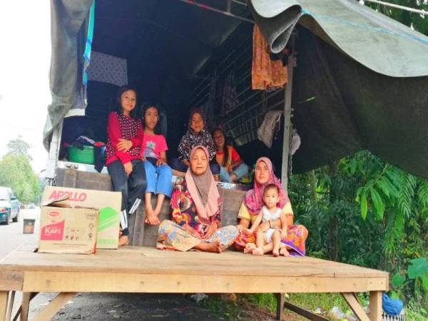 Marlina (kanan) bersama sebahagian 17 ahli keluarganya bersyukur masih ada tempat untuk berteduh.
