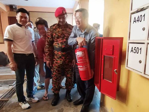 Kok Yew memasang pemadam api di Blok A Flat Alor Malai padaProgram Keselamatan Kebakaran dan Demonstrasi Pencegahan Dapur di Flat Alor Malai di sini hari ini.