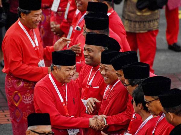 Presiden UMNO, Datuk Seri Dr Ahmad Zahid Hamidi bersama Timbalannya Datuk Seri Mohamad Hasan bersalaman bersama para perwakilan ketika hadir pada Perhimpunan Agung UMNO 2019 di Pusat Dagangan Dunia Putra (PWTC) hari ini. - Foto Bernama