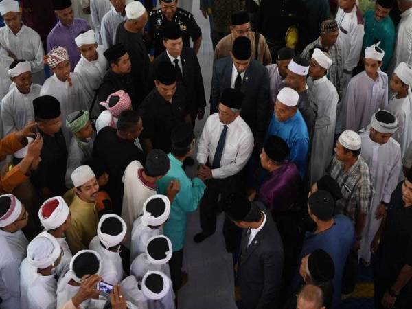 Yang di-Pertuan, Agong Al-Sultan Abdullah Shah (tengah) berkenan bersalaman dengan jemaah selepas menunaikan solat Jumaat di Masjid Jamek Al-Fallah Taman Tas, hari ini. - Foto Bernama