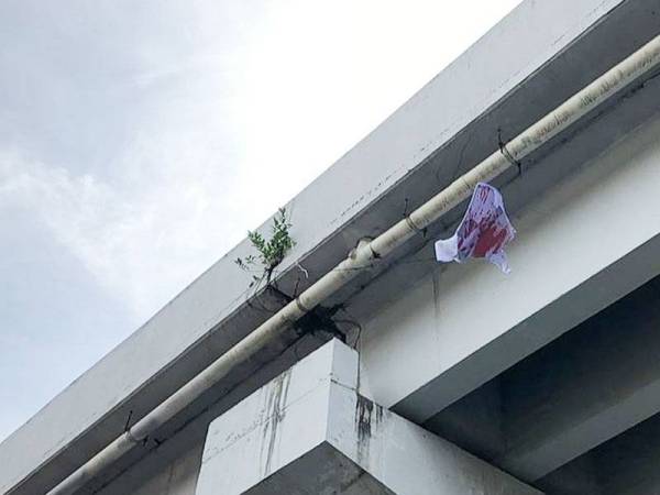 Sehelai baju putih yang disimbah cat merah ditemui tergantung di bawah laluan bertingkat menuju ke Padang Besar hari ini.