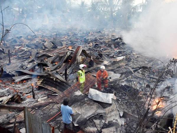 Lebih 20 keluarga tinggal sehelai sepinggang selepas 20 rumah di Kampung Titingan, di sini, musnah dalam kebakaran, petang tadi. - Foto Bernama