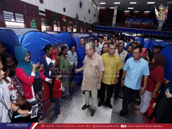 Sultan Ibrahim ketika melawat mangsa yang ditempatkan di PPS Kolej Vokasional Kota Tinggi di sini hari ini.