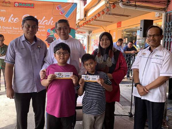 Salahuddin (belakang, dua dari kiri) bersama dua penerima bantuan Program Jom ke Sekolah, Mohamad Mukaim Nasir, 10, (depan, kiri) dan Mohd Naufal Adha, 9, anjuran Pertubuhan Peladang Kebangsaan (Nafas) yang turut melibatkan 3,200 penerima di seluruh negara hari ini. - Foto Bernama