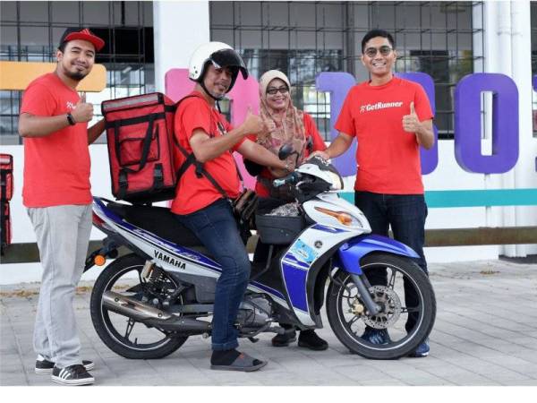 Muhammad Ziyad (kanan) yang juga pengasas syarikat GetMove Sdn. Bhd bernilai RM1 juta bersama rakan kongsinya, Khairul Ikhwan Zulkefly, 27, (kiri) bersama pekerja mereka Ahmad Zaharuddin Zakaria, 53, (dua dari kiri) dan Ayuslida Arsad, 49, ketika ditemui di pejabat mereka di TD1303 baru-baru ini. -- fotoBERNAMA 