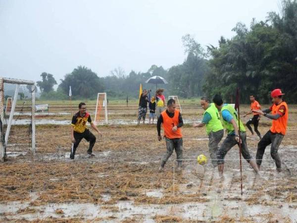 Antara aksi pemain bola sepak sawah dari pasukan pilihan Pejabat Menteri Besar dengan Pejabat Daerah Kuala Pilah.