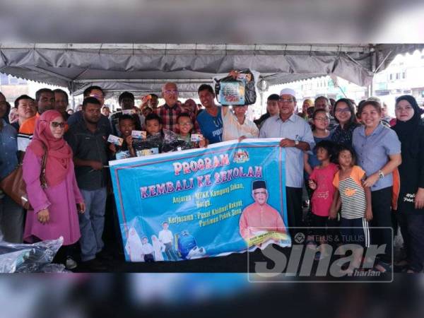 Mahfuz (tengah) bersama sebahagian 250 penerima sumbangan 'Back To School' Parlimen Pokok Sena, hari ini.