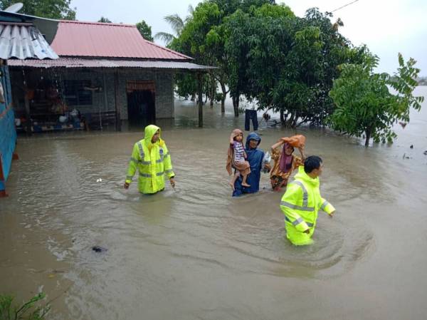 Anggota bomba dan polis memindahkan mangsa banjir selepas dua kampung di daerah Rompin dinaiki air petang tadi. FOTO: Ihsan bomba