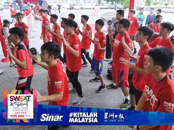 Peserta Sweat & Shoot Sukan Tanpa Diskriminasi melakukan senaman dan berzumba sebelum perlawanan bermula di perkarangan bangunan Kumpulan Karangkraf.