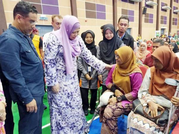 Rina (dua dari kiri) menyerahkan kaki palsu kepada Nurul Hasrina selepas program Back to School 2020@KPLB Yayasan Pelajaran Malaysia di Dewan Ibby Khaldun, KKTM Kuantan semalam.