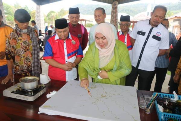 Shahaniza mencanting batik sambil diperhatikan Mohd Ariffin (dua dari kiri) sempena perasmian mesyuarat pertama pertubuhan tersebut di Lanab Qalbu Maran.
