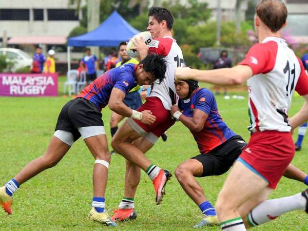 Pemain UAE, Alistair Hess (dua, kiri) diasak dua pemain negara Muhammad Fuad Mohd Saleh (kiri) dan Adam Arif Alias (tiga, kiri) pada Kejohanan Ragbi Asia B-19 Divisyen Dua di UPM hari ini.