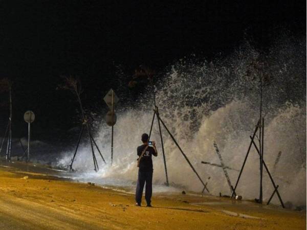 Syed Azam ketika meninjau ombak kuat menghempas benteng pemecah ombak hingga menyebabkan air melimpah di atas jalan raya ketika tinjauan Bernama di Pantai Seberang Takir, malam tadi. - Foto Bernama