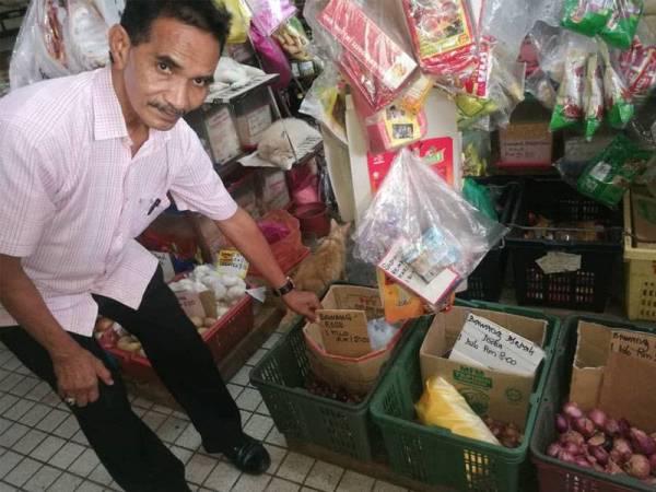 Mohd Fauzi menunjukkan bawang merah kecil rose yang kini dijual RM12 sekilogram di Pasar Besar Alor Setar di sini.