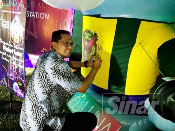 Mohd Asmirul menandatangani mascot Luna sempena pelancaran ‘Luna Lights Wonderland’ dan kolaborasi amal bersama KFA, di Taman Tasik Darulaman, Jitra malam tadi.