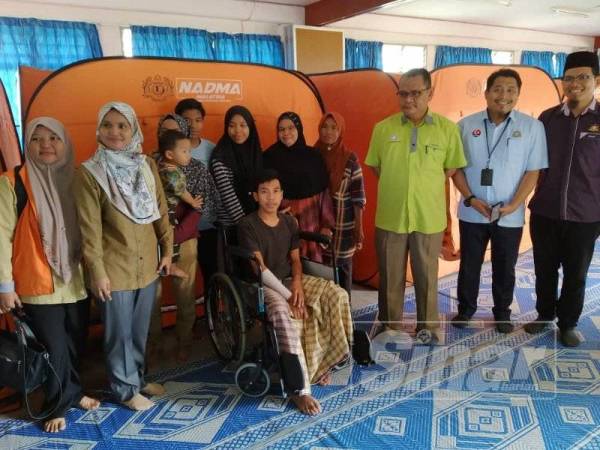 Shida (tiga dari kanan) dan Mohd Shafik yang berkerusi roda ketika dikunjungi Zulkiflee di PPS SMK Suria Perdana Batu Pahat hari ini.