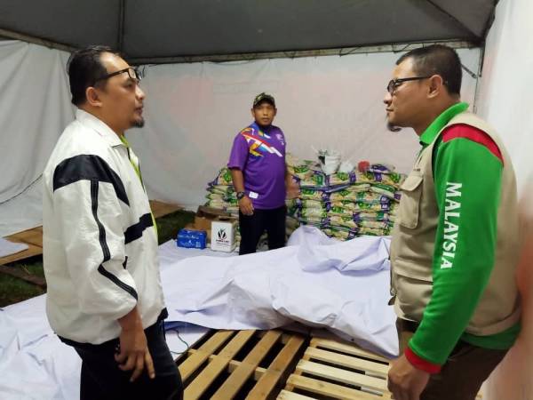 Muhammad Azwan (kiri) menerima lawatan dari Pengarah Khidmat Malaysia, Khairul Faizi Ahmad Kamil yang melawat pusat pengumpulan barang bantuan banjir di Seri Gombak.