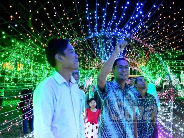 Mohd Asmirul (kanan) meninjau hiasan lampu LED dan lampu bintang pelbagai corak dan tema yang mendapat sambutan pengunjung.