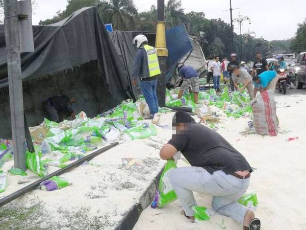 Gelagat beberapa orang awam ketika mengerumuni lori beras yang terbalik dalam kemalangan itu.