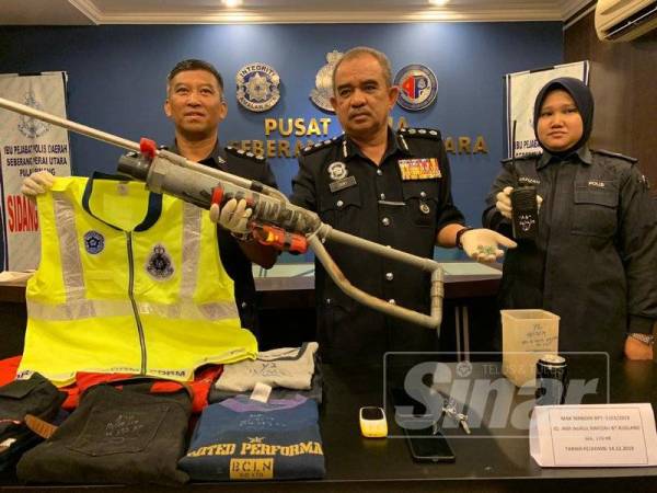 Noorzainy (tengah) menunjukkan senapang angin dan vest bertulis PDRM yang dirampas dari suspek tadi.