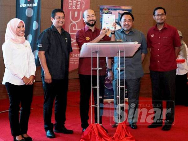 Mukhriz (tengah) menunjukkan buku Direktori Pelancongan Negeri Kedah yang dilancarkan sambil disaksikan Uzaidi (dua dari kiri) ketika gimik pelancaran hari ini.